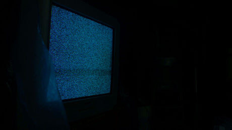 a television in a dark room with a blue screen