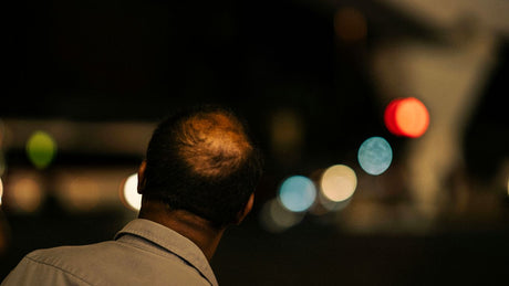 a man standing in front of a street at night