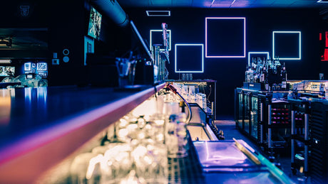 a dimly lit bar with many empty glasses