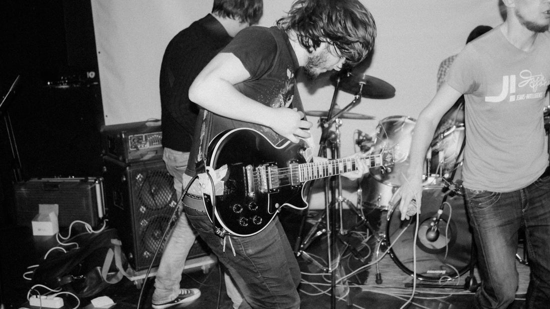 man playing guitar beside woman in black t-shirt