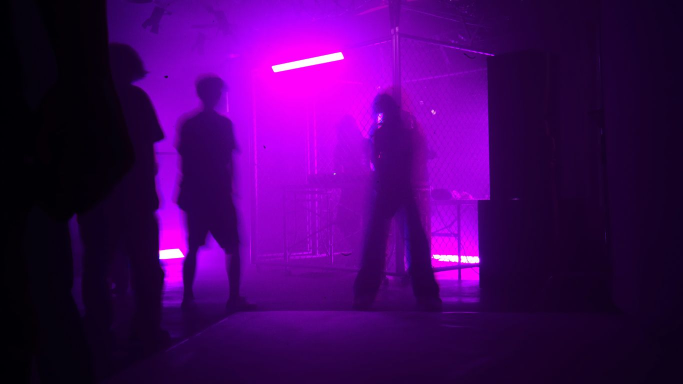Silhouettes of people in purple stage lighting