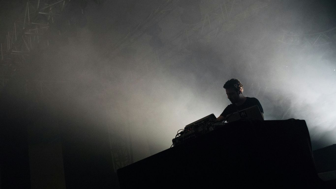 grayscale photography of man standing and playing audio mixer