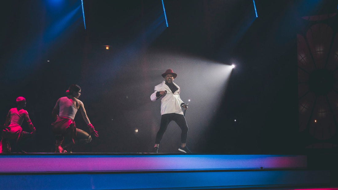 person wearing white suit performing on stage