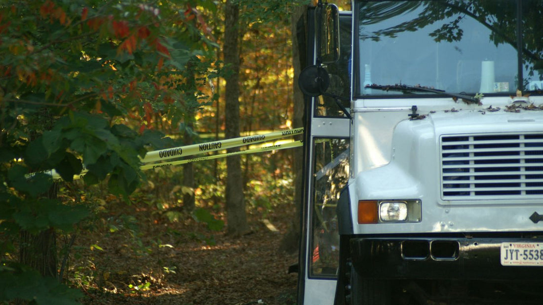 White truck parked near trees with yellow tape.