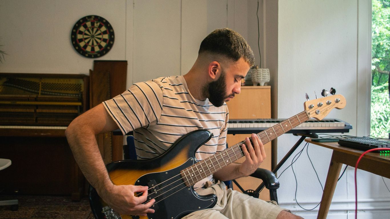 A man playing a guitar in a living room